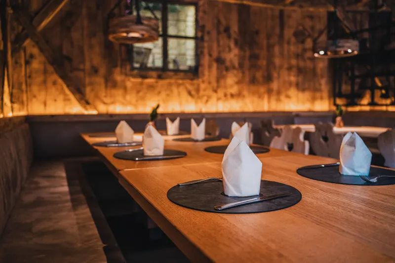 Stube in legno con tavoli apparecchiati, fotografia di Team247 per un ristorante in Alto Adige